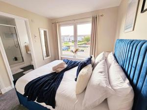 1 dormitorio con 1 cama y 1 sofá con ventana en Modern 5 Bedroom Townhouse with Free Parking en Glasgow