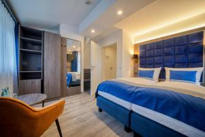 sypialnia z dużym niebieskim łóżkiem i krzesłem w obiekcie Zentrum Hotel Stade w mieście Stade