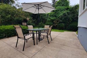 a table with chairs and an umbrella on a patio at Unique & Peaceful Boston Home( Free Parking) in Boston