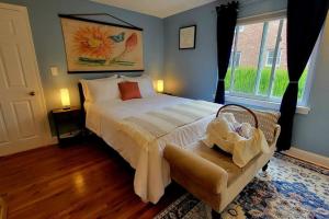 a bedroom with a bed and a chair and a window at Unique & Peaceful Boston Home( Free Parking) in Boston