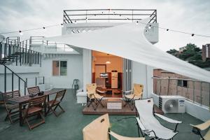 een patio met stoelen en een witte tent op een dak bij Stay Ccassette Player in Mokpo