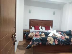 Sikkimese Inn في Ravangla: غرفة نوم بسرير مع مفرش مع ورد