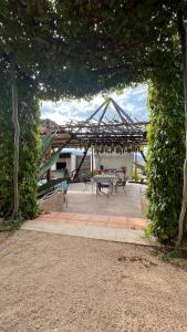 a pavilion with a table and chairs under a tree at Santerra, Valle de Guadalupe in Valle de Guadalupe