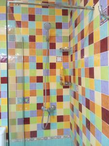 a shower in a bathroom with a colorful tiled wall at Famarabeach in Famara
