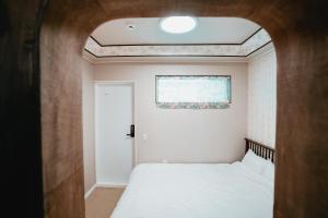 - une petite chambre avec un lit et une fenêtre dans l'établissement Stay Ccassette Player, à Mokpo