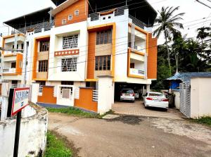 a building with cars parked in front of it at Thrissur Villas Home Stay in Trichūr