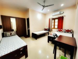 um quarto com 2 camas, uma secretária e uma mesa em Thrissur Villas Home Stay em Thrissur