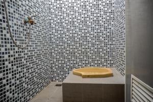 een badkamer met een douche en een toilet. bij SPOT ON 93144 Homestay H. Syarif Syariah - Bandar Gresik 2 in Gresik