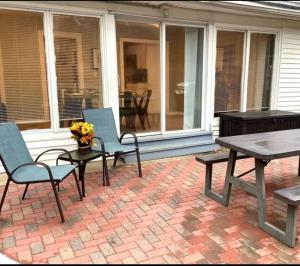 a patio with two chairs and a table and a bench at Revere Lower in Cleveland