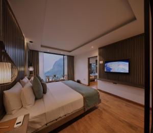 a bedroom with a large bed and a flat screen tv at HIDE ELLA Hotel & Resort in Ella