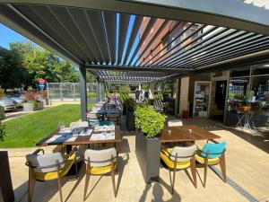 a patio with tables and chairs under a pergola at A Blok Top Living in Belgrade