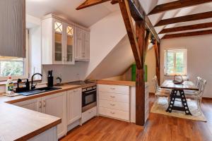 a kitchen with white cabinets and a table in it at Chata Zadov in Prachatice