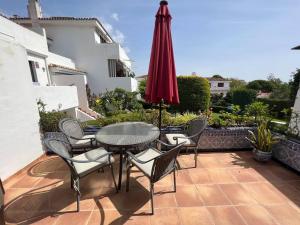 a patio with a table and chairs and an umbrella at Casa de Playa in Estepona