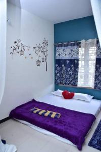 a bedroom with a bed with a purple blanket at Citylight Family Homestay in Mysore