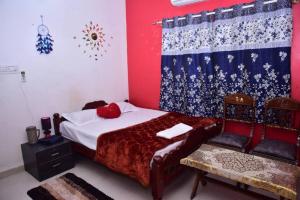 a bedroom with a bed and a chair in it at Citylight Family Homestay in Mysore