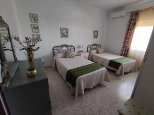 1 dormitorio con 2 camas, mesa y espejo en Alojamiento Rural Casa la Abuela, en Arbuniel