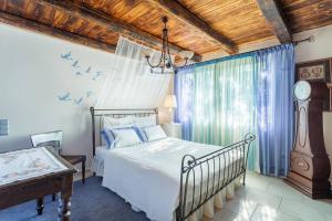een slaapkamer met een bed en een klok in een kamer bij Turdus Merula Retreat in Nea Makri