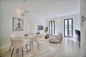 ein weißes Wohnzimmer mit Tisch und Stühlen in der Unterkunft REF 1916 - Beautiful apartment for rent in Cannes in Cannes + 15 Fotos