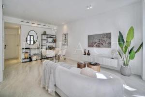 un soggiorno bianco con divano bianco e tavolo di REF 1916 - Beautiful apartment for rent in Cannes a Cannes