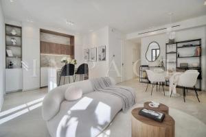 un soggiorno bianco con divano e tavolo di REF 1916 - Beautiful apartment for rent in Cannes a Cannes