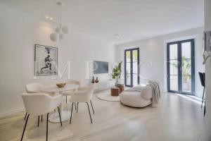 un soggiorno bianco con tavolo e sedie di REF 1916 - Beautiful apartment for rent in Cannes a Cannes
