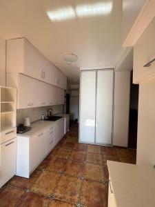 a kitchen with white cabinets and a tile floor at Apartament Zloty Pociag in Wałbrzych