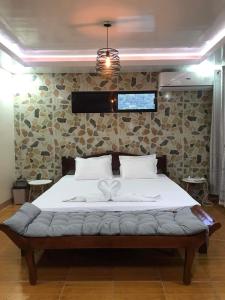 ein Bett in einem Schlafzimmer mit einer Steinmauer in der Unterkunft Top floor apartment in Dapa