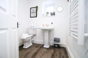 biała łazienka z umywalką i toaletą w obiekcie Casa di pietra - Cardiff City centre apartment with patio, Free private parking w Cardiff