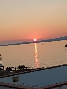 zachód słońca nad wodą z łodzią w obiekcie Casa Vacanze Fronte Mare Calasetta "CA' U CAPPUN" w mieście Calasetta
