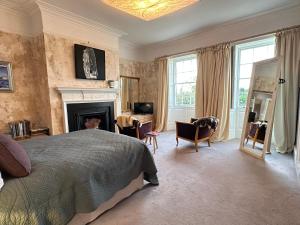 a bedroom with a bed and a fireplace at The Priory 