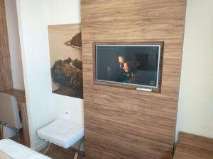 a tv on a wall in a room at Quarto 501 do Design Hotel Linhares in Linhares