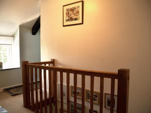 a staircase with a picture on the wall at Grafog Farm Cottage in Groeslon