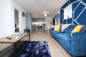 salon z niebieską kanapą i stołem w obiekcie Casa di pietra - Cardiff City centre apartment with patio, Free private parking w Cardiff