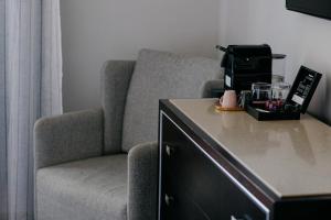 een woonkamer met een stoel en een koffiezetapparaat bij Excelsior INN in Turda