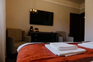a hotel room with a bed and a flat screen tv at Excelsior INN in Turda +158 photos
