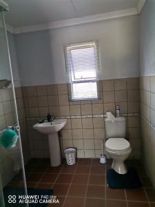 a bathroom with a toilet and a sink at Khutsong Lodge in Acornhoek