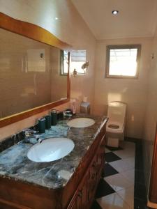 a bathroom with two sinks and a toilet at Sunset View La Cote D 'Azure in Pamplemousses Village