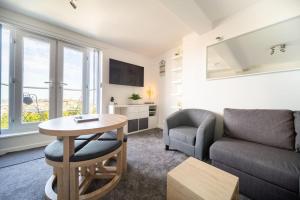 uma sala de estar com um sofá e uma mesa em Newquay Sunset & Sea View Apartment in Town Centre em Newquay