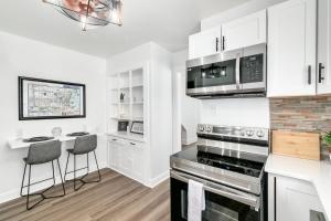 a kitchen with white cabinets and a stove top oven at Satoshi Hideout Sol Apartments in St Petersburg