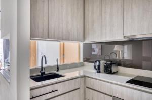 a kitchen with white cabinets and a sink at Cozy 2BR Apartment! in Singapore