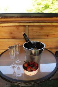 a table with a bucket of strawberries and a bottle of wine at Pembrokeshire Shepherd hut with hottub in Jordanston