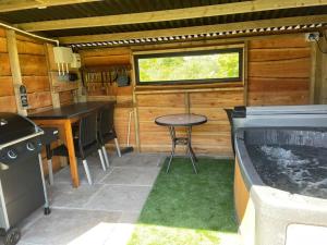 una cucina con griglia e tavolo in una cabina di Pembrokeshire Shepherd hut with hottub a Jordanston