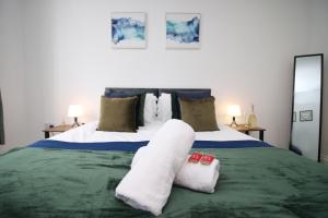 sypialnia z łóżkiem z ręcznikami w obiekcie Casa di pietra - Cardiff City centre apartment with patio, Free private parking w Cardiff