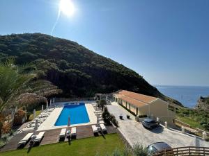 a villa with a swimming pool next to the ocean at Corfu valley view in Paleokastritsa