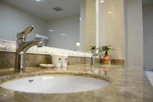 un bagno con lavandino e specchio di GreenTree Inn JiangSu WuXi YiXing East LongTan Road DongJiu Business Hotel a Yixing