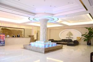 un atrio con una colonna al centro di un edificio di GreenTree Inn JiangSu WuXi YiXing East LongTan Road DongJiu Business Hotel a Yixing