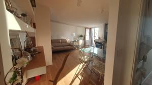 ein Wohnzimmer mit einem Sofa und einem Glastisch in der Unterkunft EmmeGI Home di fronte alla Fiera di Foggia in Foggia