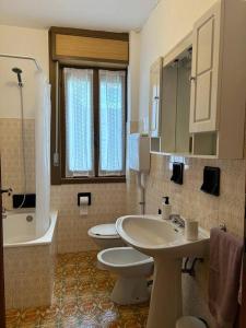 a bathroom with two toilets and a sink and a tub at Appartamento del Sole in Borno +31 photos