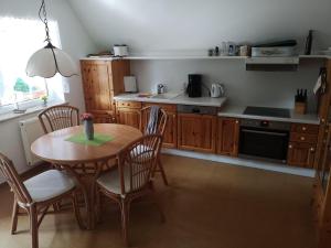 a kitchen with a wooden table and chairs and a kitchen with a stove at Ferienwohnung-im-Gruenen-zwischen-Binz-und-Sellin in Zirkow