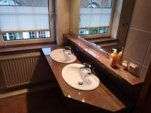 a bathroom with two sinks and a large mirror at Ferienwohnung-im-Gruenen-zwischen-Binz-und-Sellin in Zirkow +10 photos